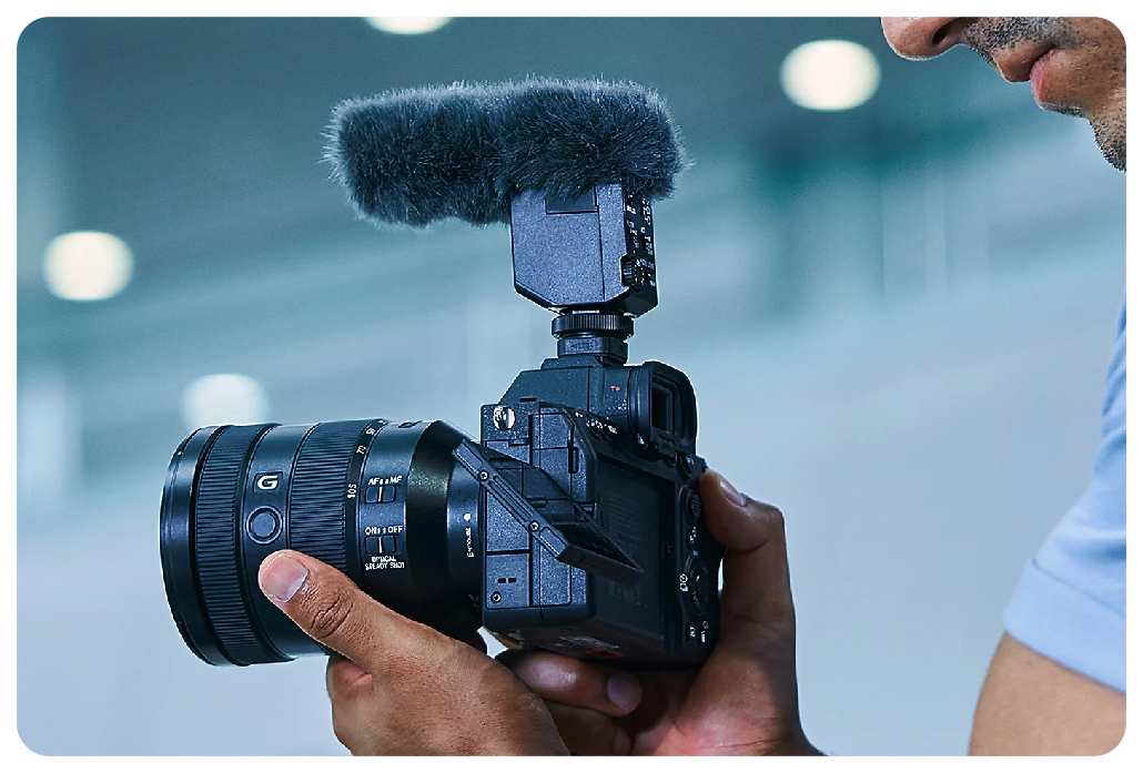Sony A7 IV Mirrorless Camera with lens and microphone held by filmmaker recording video